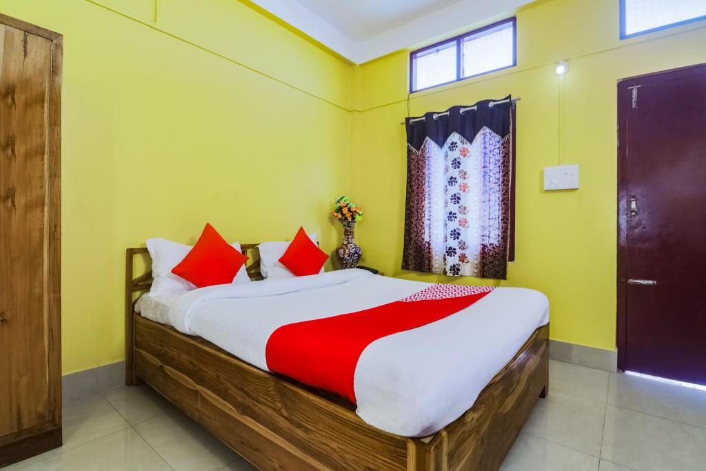 BhutiāgāonOYO Alohi Ghar的一间卧室配有一张带红色枕头的大床