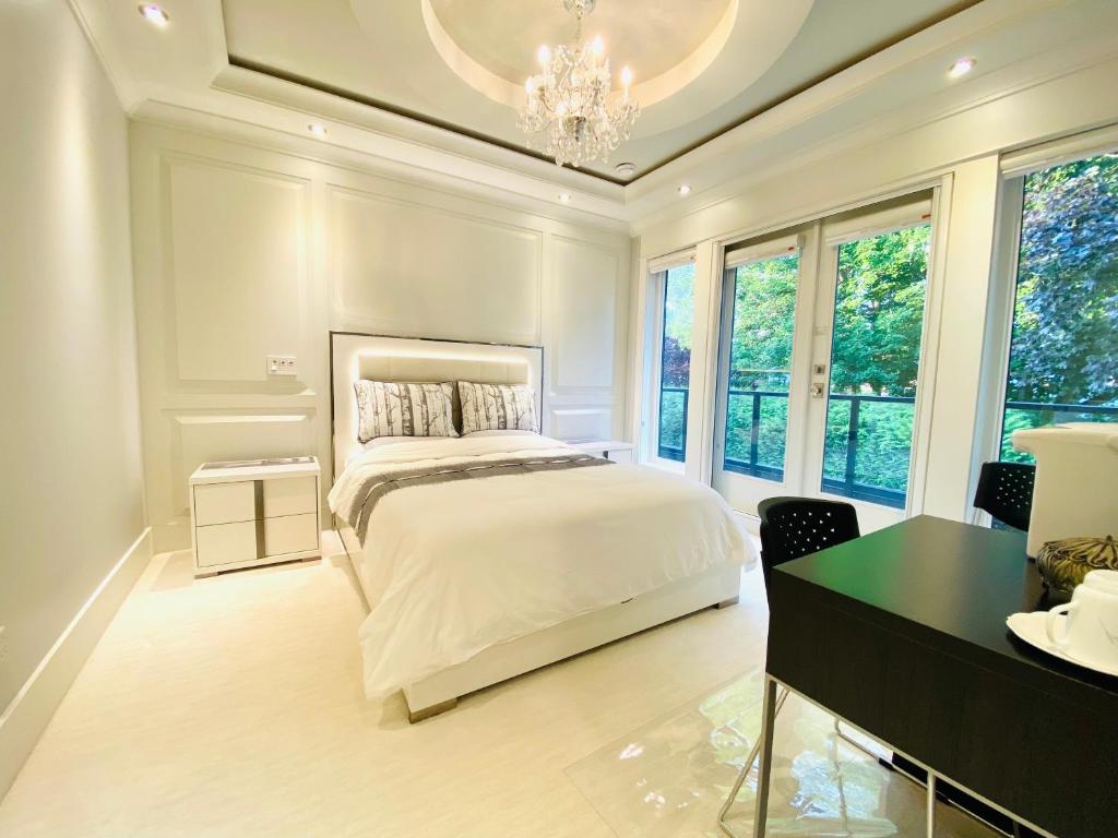里士满Vancouver Shangrila House的卧室配有一张床、一张书桌和窗户。