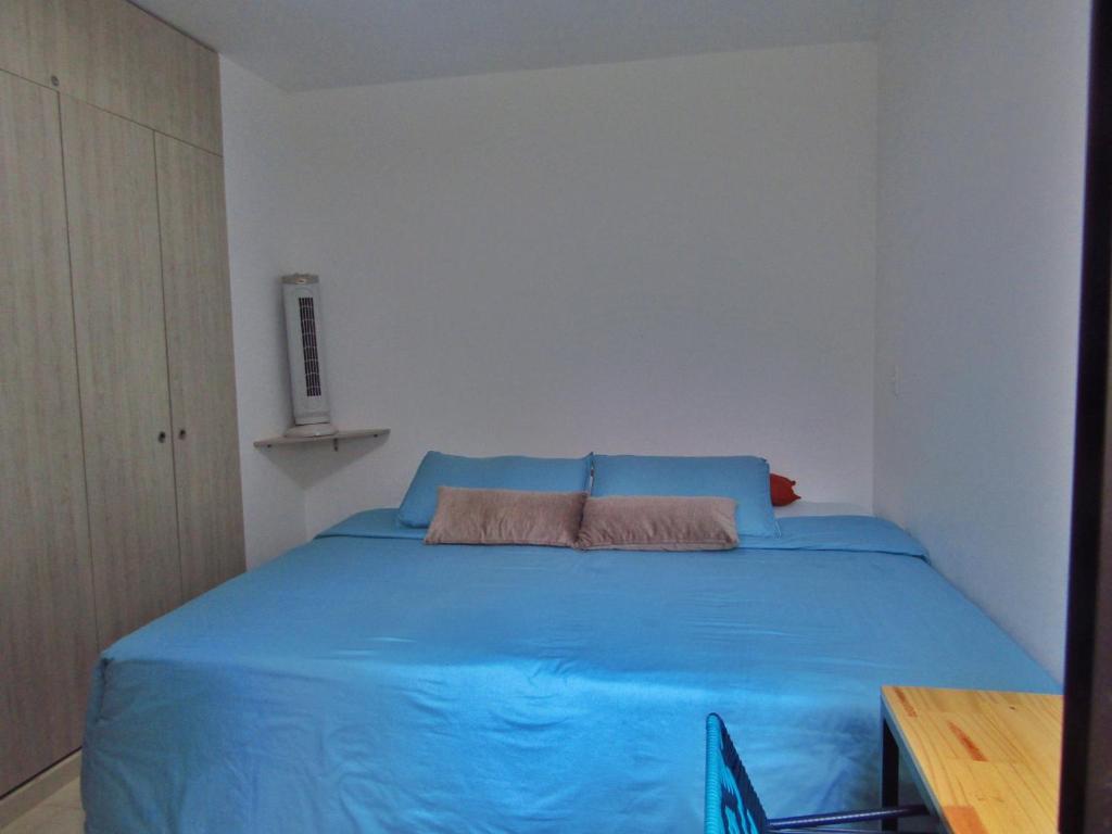 拉特瓦伊达hermoso apartamento amoblado的一间位于客房内的蓝色床卧室