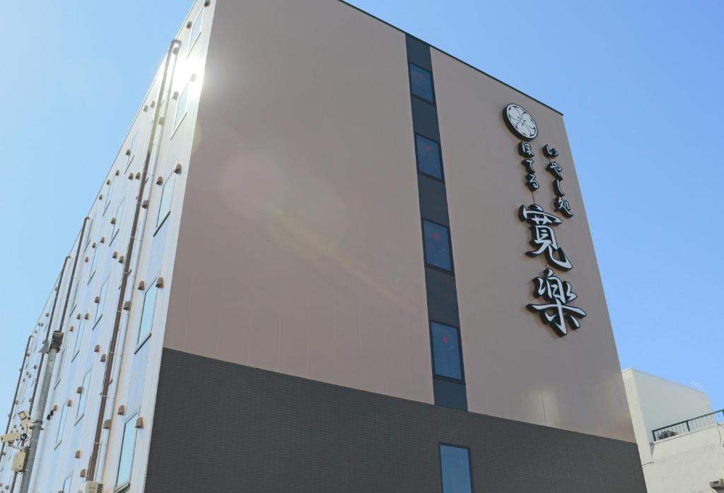 秋田Hotel KAN-RAKU Akita Kawabata的建筑的侧面有标志