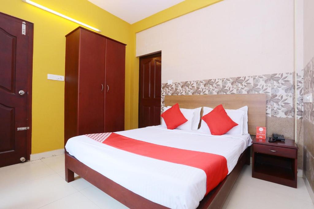 戈德亚姆Hotel Day Springs的一间卧室配有一张带红色枕头的大床