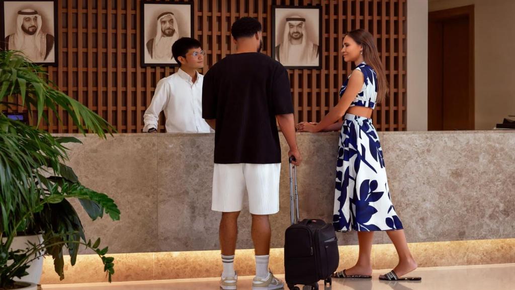 阿布扎比Andalus Al Seef Resort & Spa的站在墙上的男人和女人