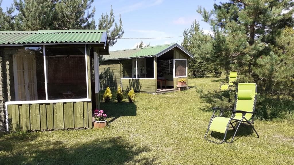 哈普萨卢Kastani Camping的庭院中带绿色屋顶和椅子的房子