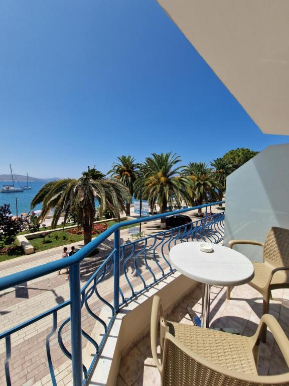 萨兰达考尼亚酒店的一个带桌椅和海滩的阳台