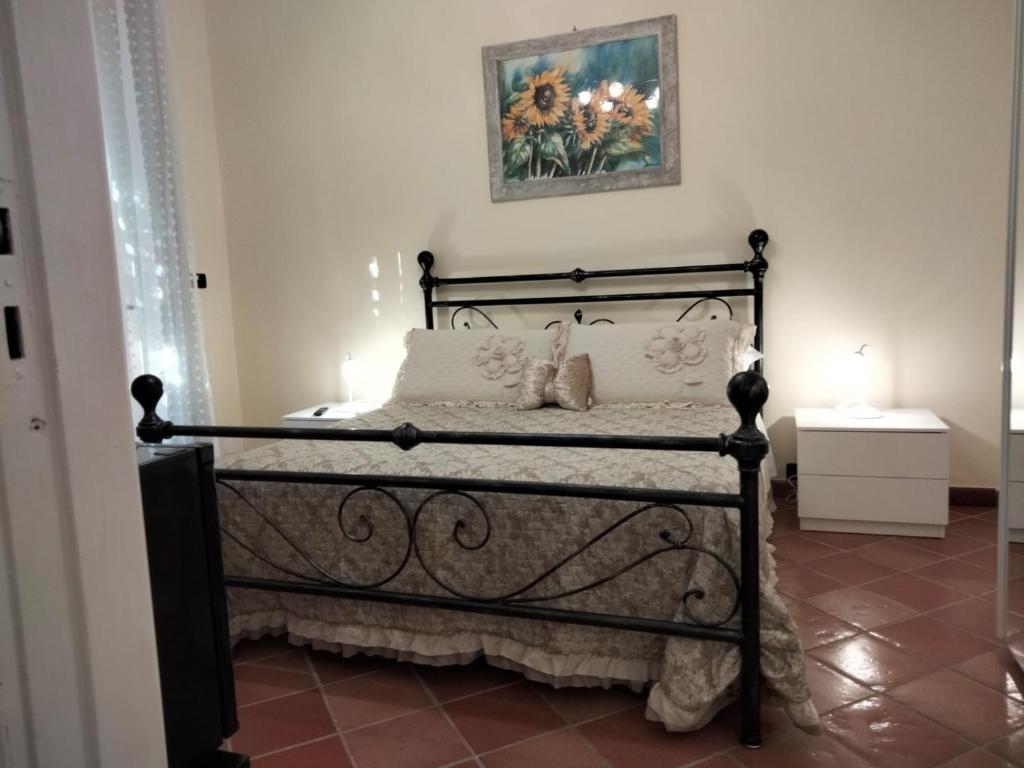 圣温琴佐La Casa di Lisa的卧室配有一张黑色床,墙上挂着一张照片