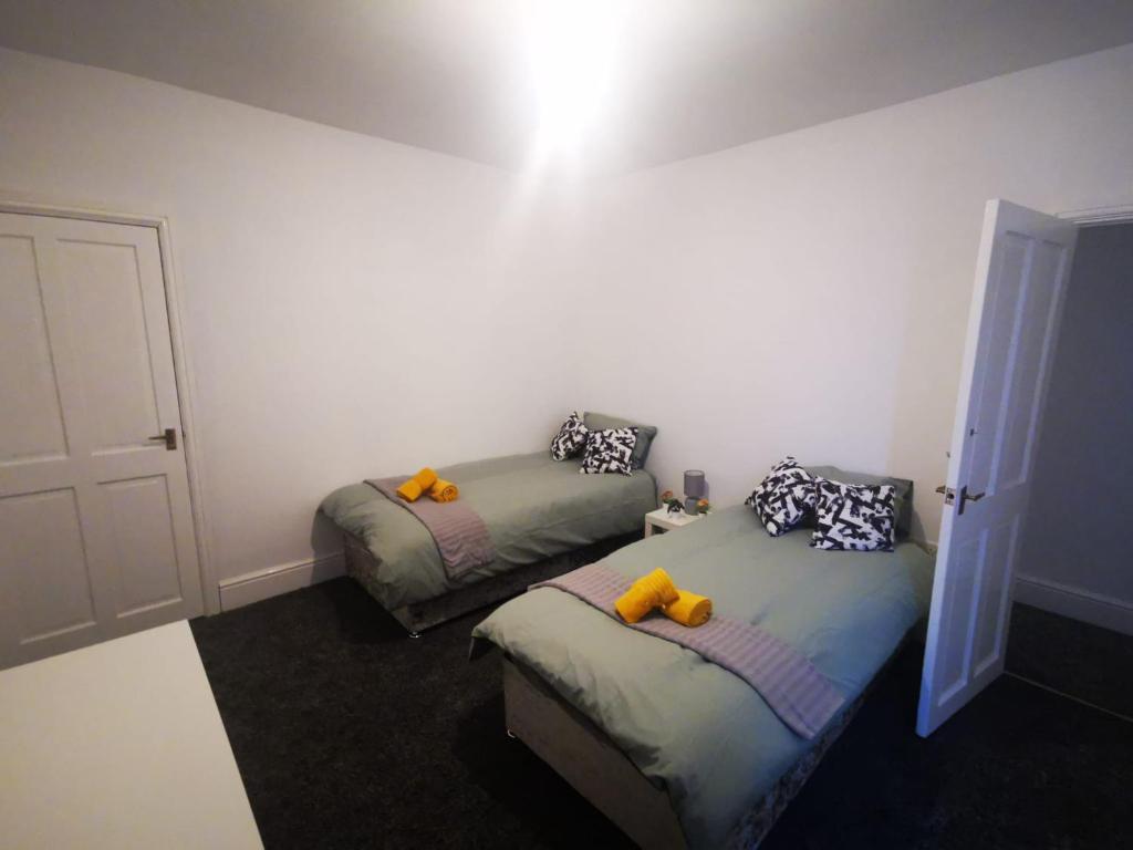 德比Twin Room - Sutherland Place的一间卧室配有两张带黄色枕头的床。