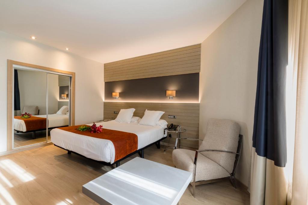 拉科鲁尼亚阿文尼达酒店的配有一张床和一把椅子的酒店客房