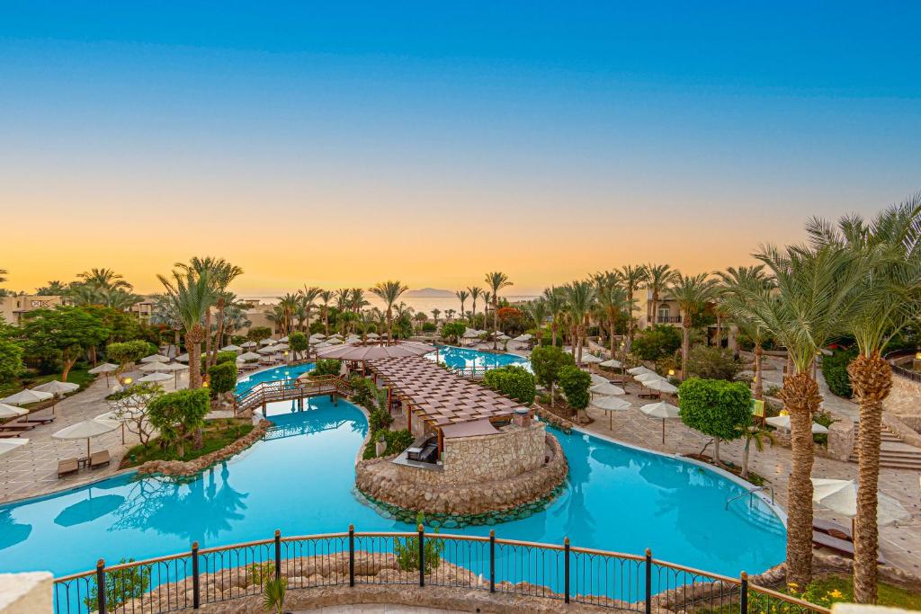 沙姆沙伊赫The Grand Hotel Sharm El Sheikh的棕榈树度假村泳池的空中景致