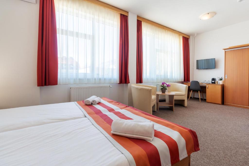 佩奇弗洛丹佩奇酒店的酒店客房,设有一张带红色窗帘的大床