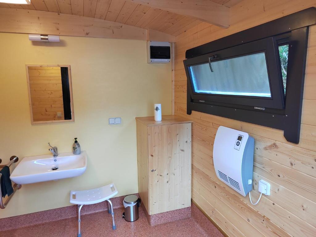 弗瑞兰la Yourte des Bibis的一间带水槽的浴室和墙上的电视