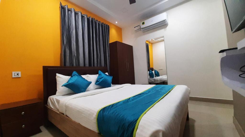 坦贾武尔Hotel Abedrooms- Budget stay Thanjavur的一间卧室配有一张带蓝色枕头的大床