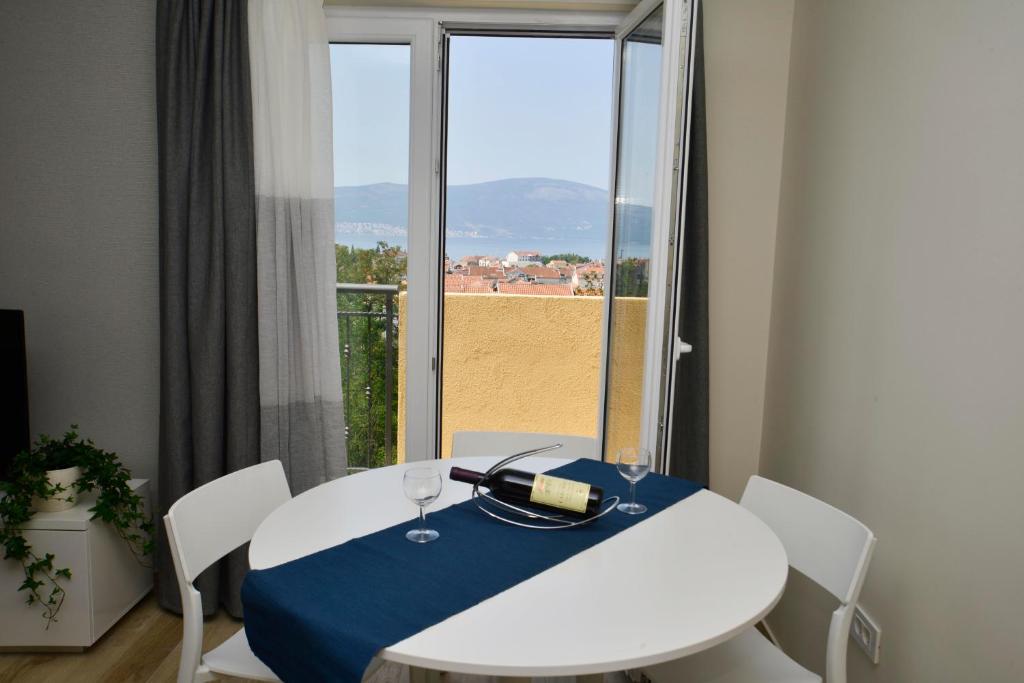 蒂瓦特Bradasevic Apart Resort Tivat的一张桌子,上面放着一瓶葡萄酒,还有一个窗口