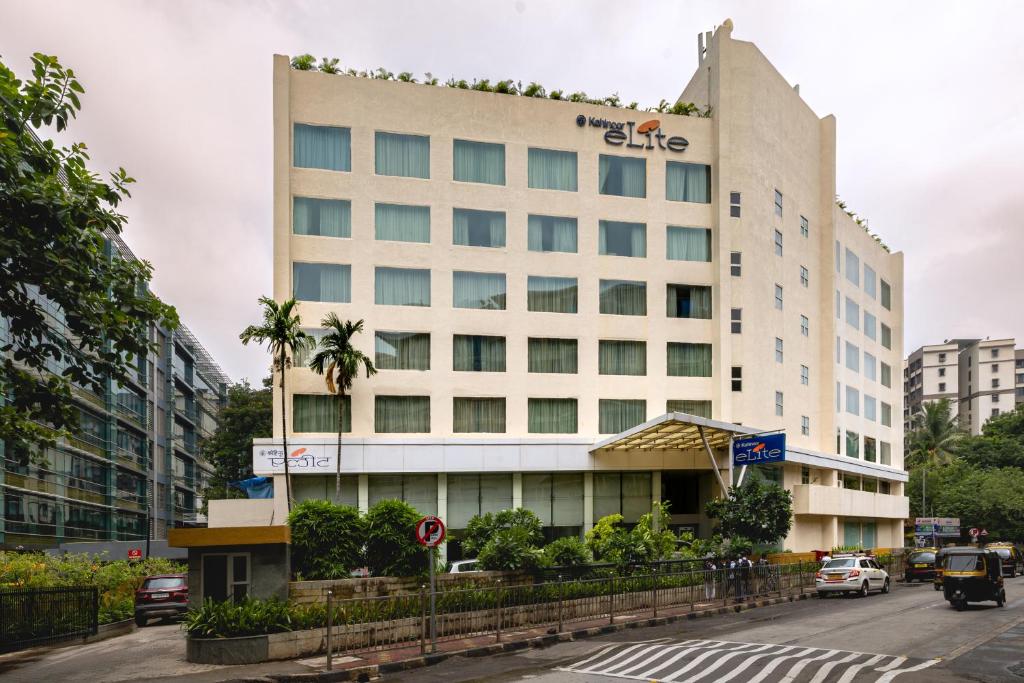 孟买Hotel Kohinoor Elite near BKC的一座高大的白色建筑,上面有标志