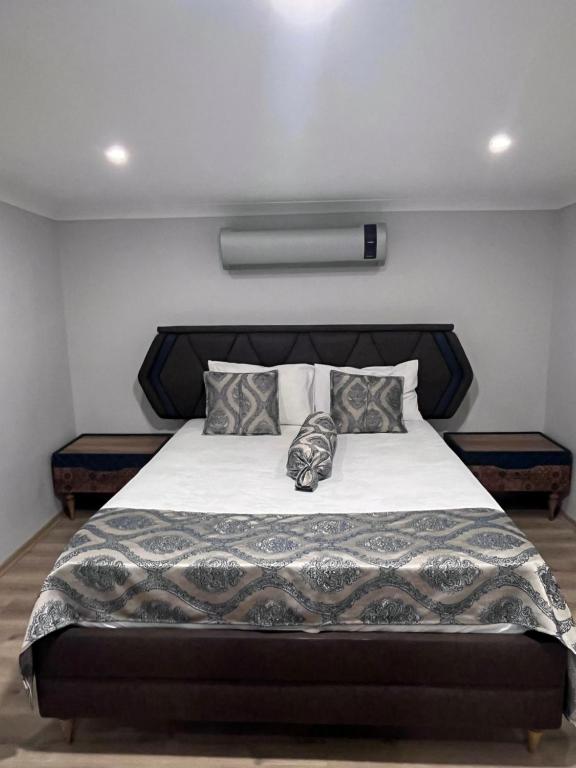 PelitliBayraktar apart的卧室配有一张带白色床单和枕头的大床。
