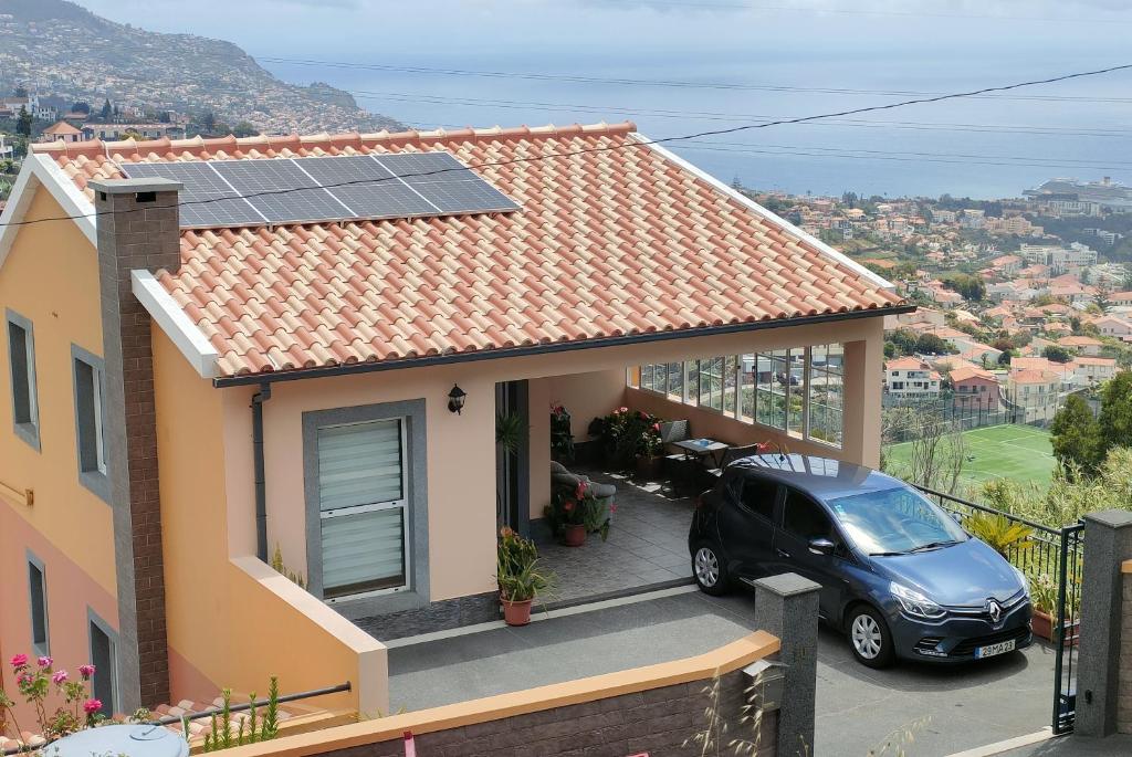 丰沙尔Costa Residence Funchal View的屋顶上设有太阳能电池板的房子