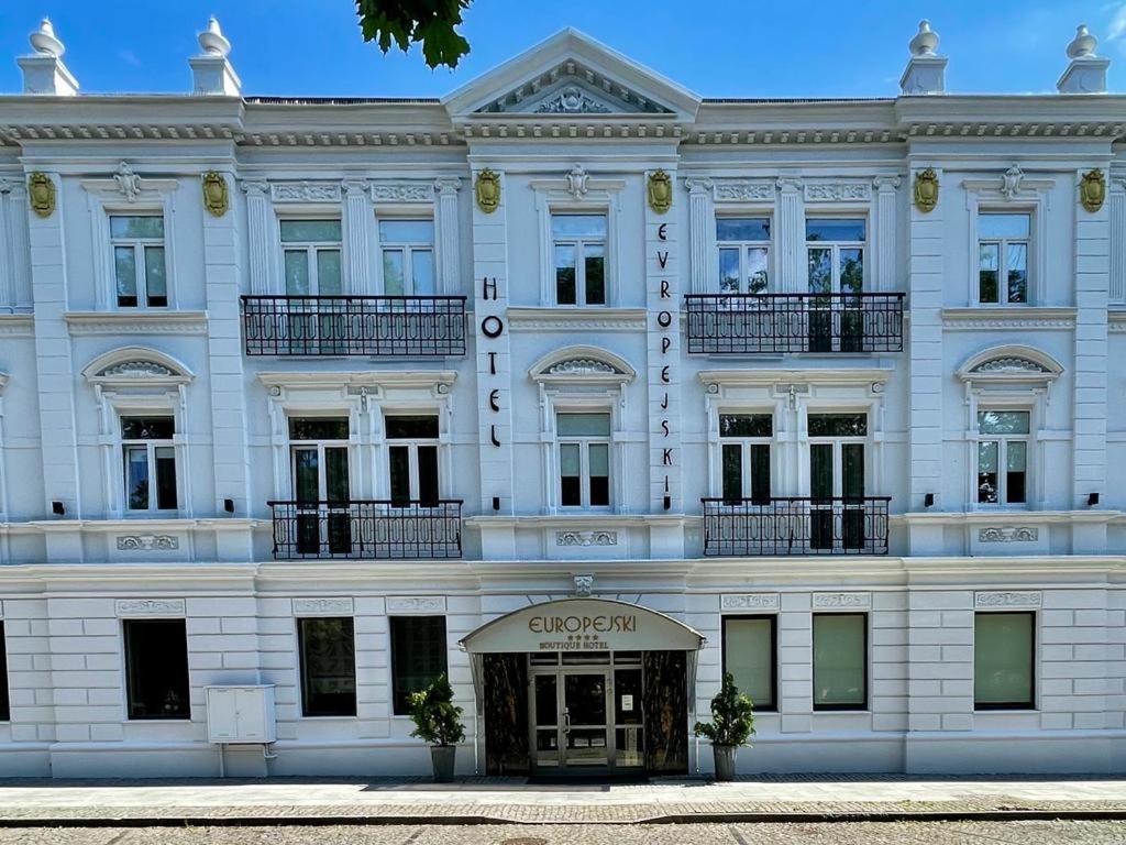 拉多姆优瑞斯凯精品酒店的大型白色建筑,设有窗户和阳台