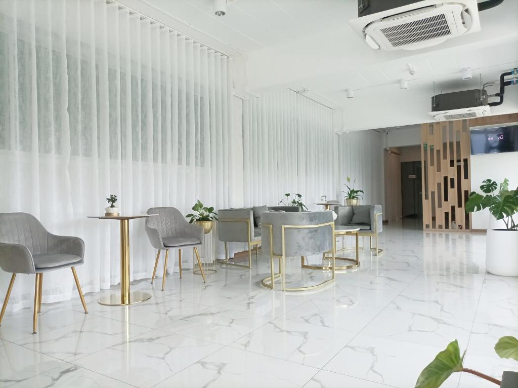 曼谷Golden Nest Hotel Suvarnabhumi的配有桌椅的房间和墙壁