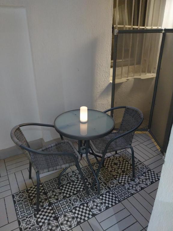 马德里Céntrico apartamento con patio的一张桌子上的蜡烛,两张椅子
