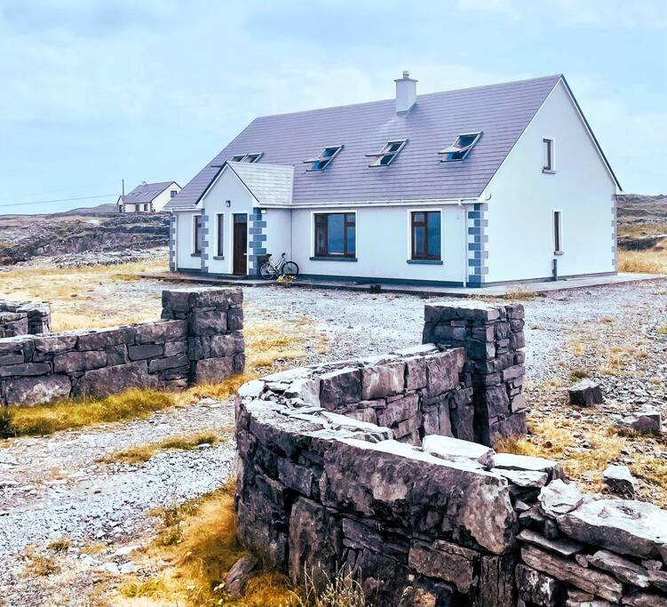 BungowlaIrish Isle Oasis: Spacious 5-Bedroom Retreat的石墙的田野上的白色房子