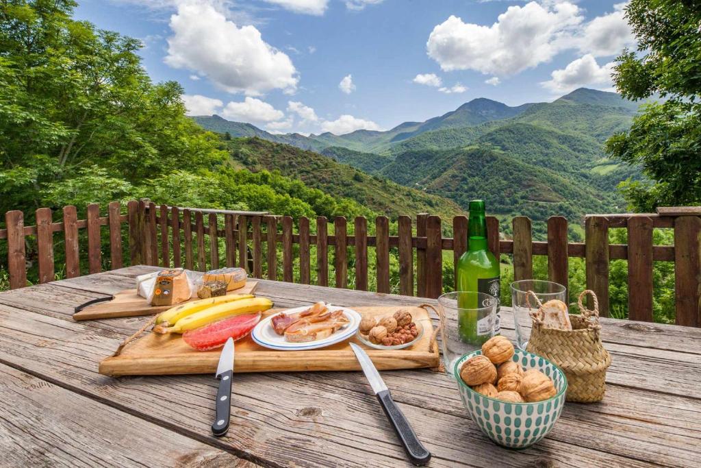 拉普拉萨La Congosta mágica aldea rodeada de montañas的一张野餐桌,上面放着一盘食物和一瓶葡萄酒