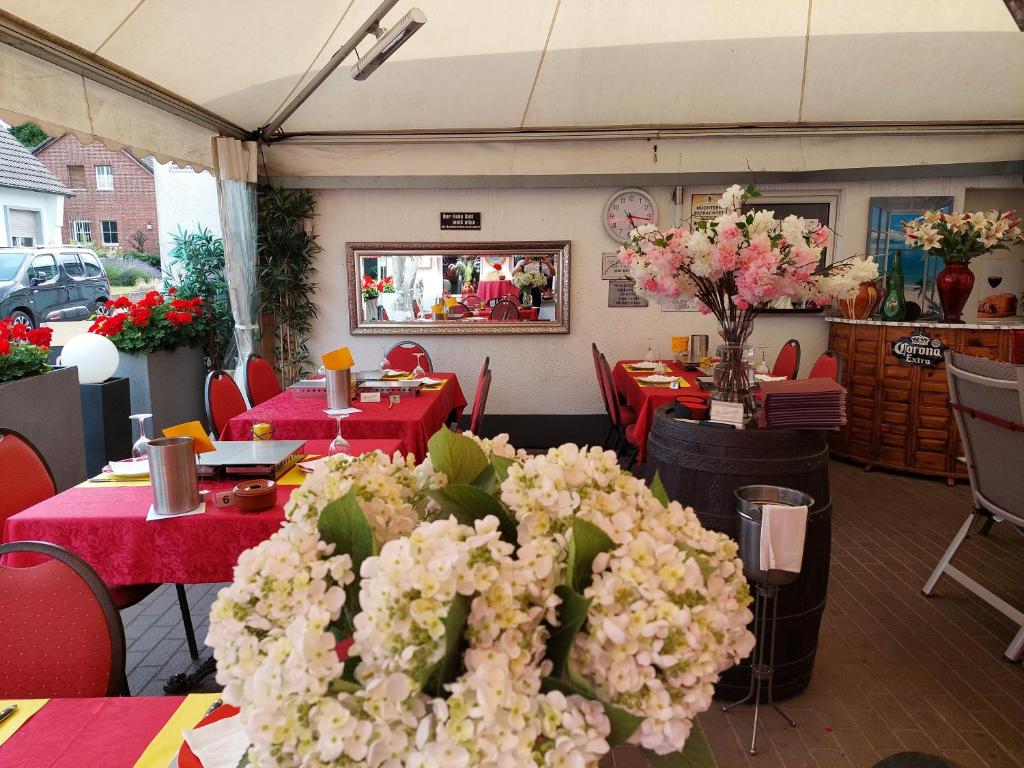 菲尔森Tapas restaurante 1的一间设有红色桌子和白色鲜花的餐厅