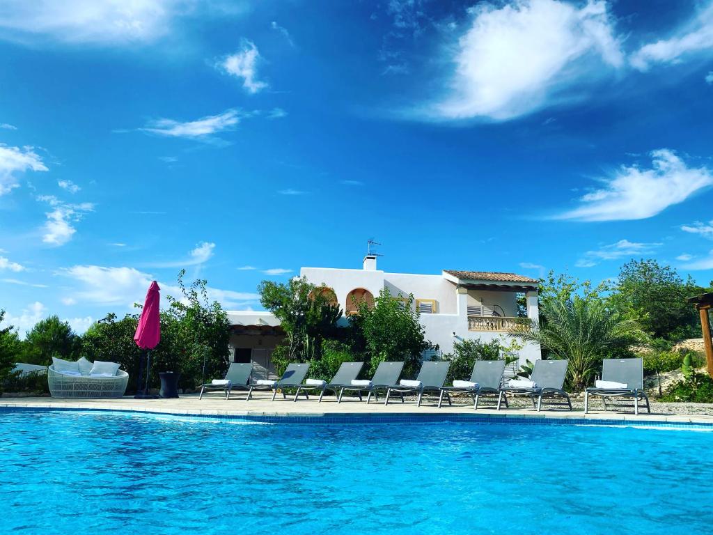 圣塔格鲁迪斯Villa Can Toni Miquelí的一个带椅子的游泳池和一个背景房子