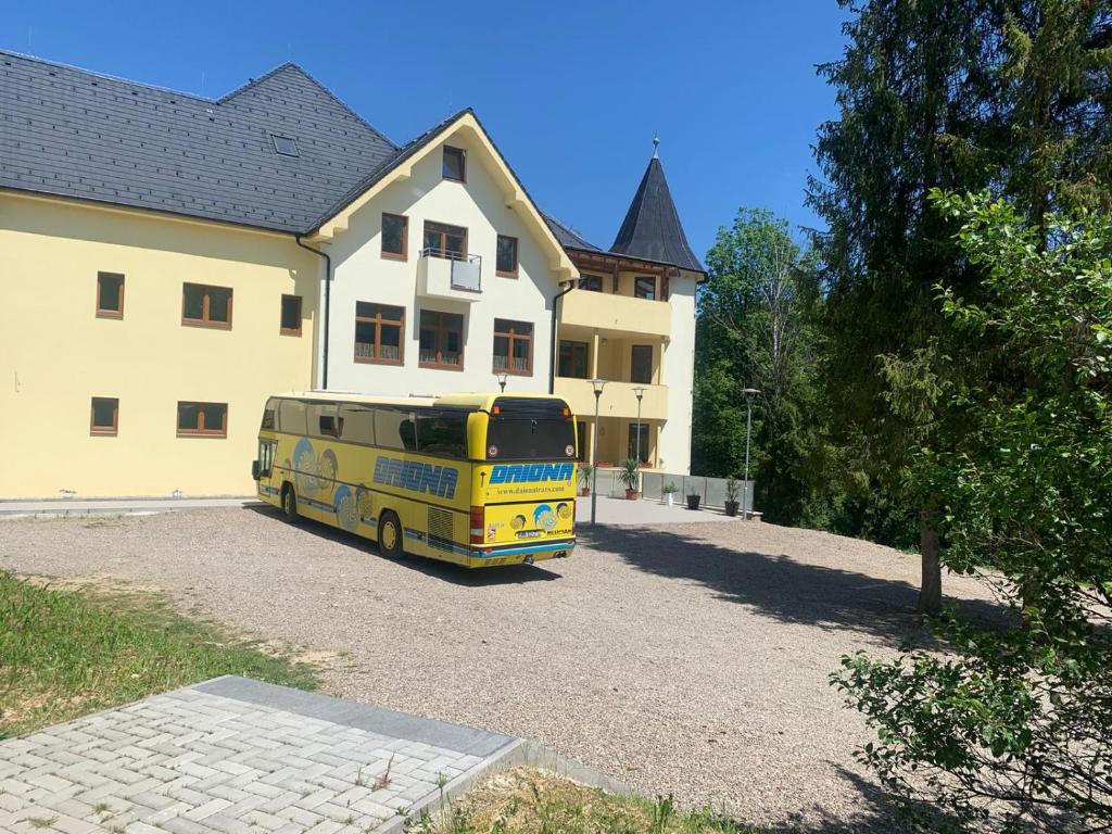 Nová ľubovňaPenzión Probstner的停在房子前面的黄色巴士