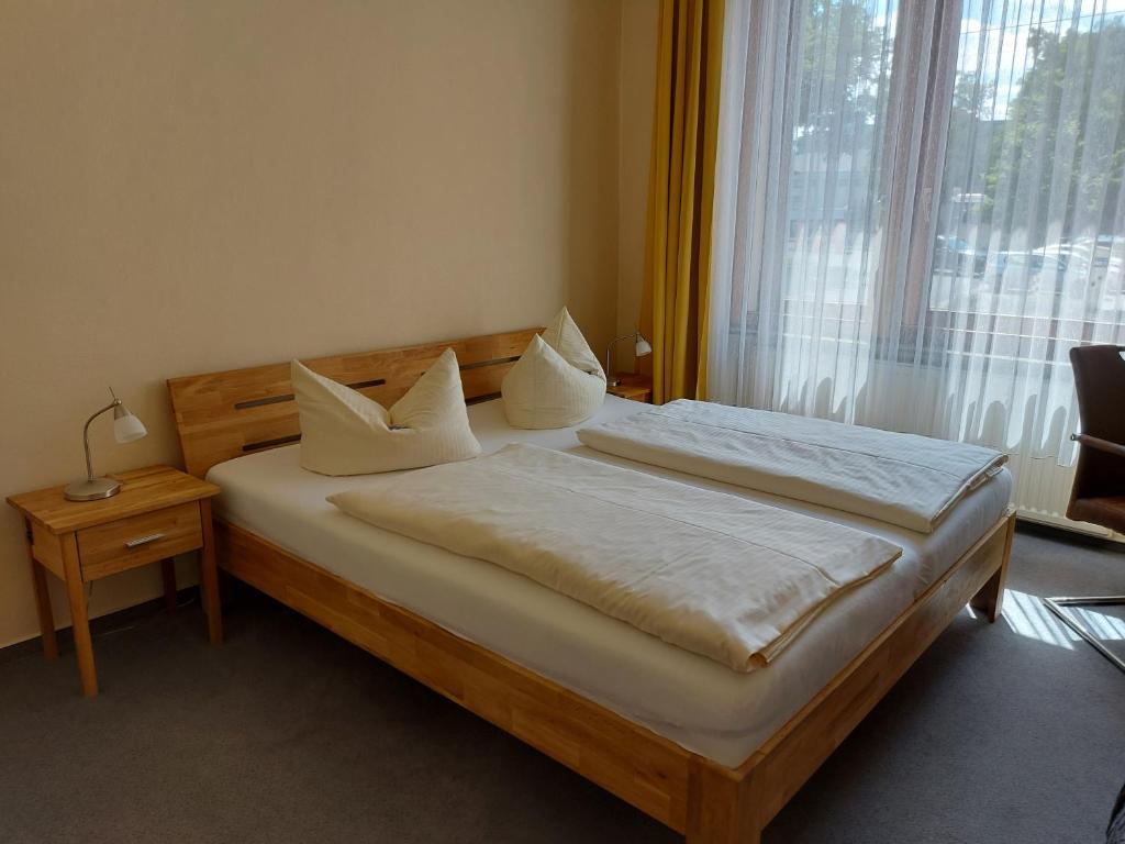布伦瑞克施塔特哈勒酒店的卧室配有带白色枕头的床和窗户。