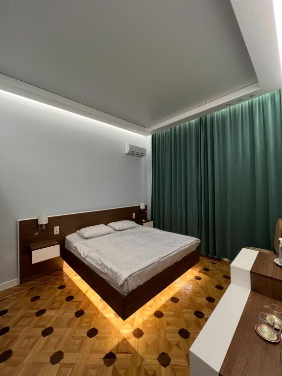 库塔伊西Marco Polo的一间卧室配有床和绿帘