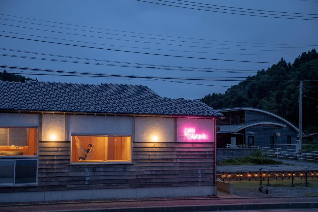 七尾OH!TOMARI的旁边有一个 ⁇ 虹灯标志的房子