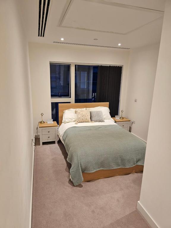 克罗伊登Santina Apartments的一间卧室设有一张大床和两个窗户。