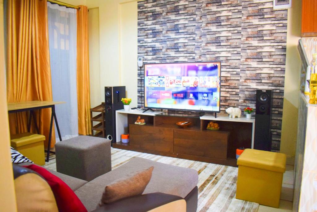 基苏木Casabella Apartment - Pristine Homes,Tom Mboya的一间带电视和沙发的客厅