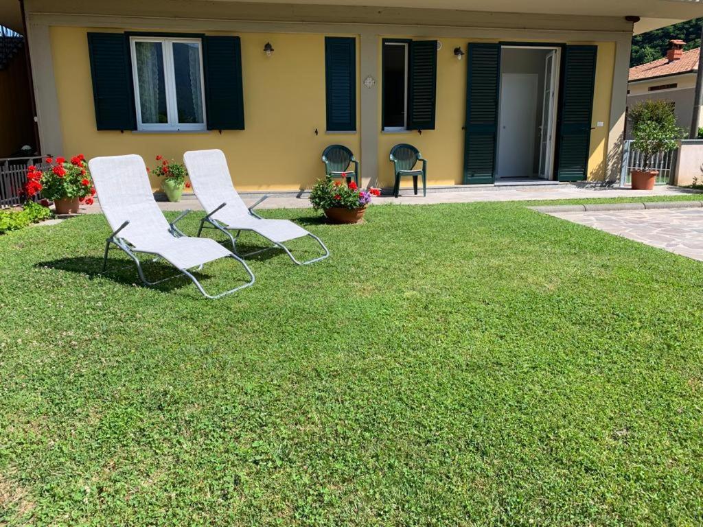加利安奴Elicriso的两把白色椅子坐在房子前面的草坪上
