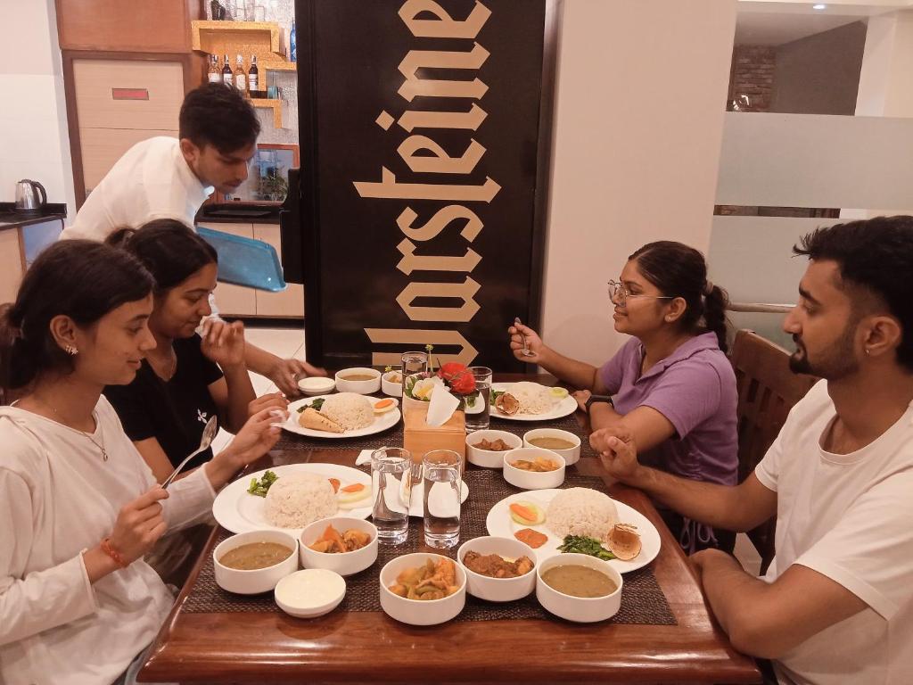 加德满都Hotel Krishna Kathmandu的一群坐在桌子旁吃食物的人