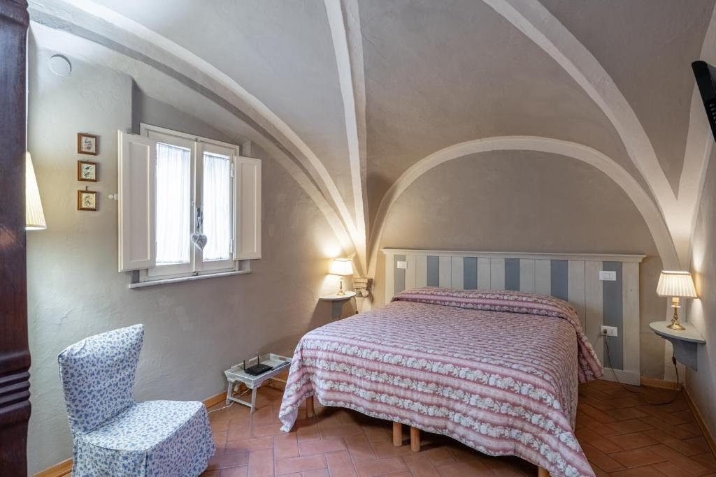 皮斯托亚Residenza Gatteschi的卧室配有床、椅子和窗户。