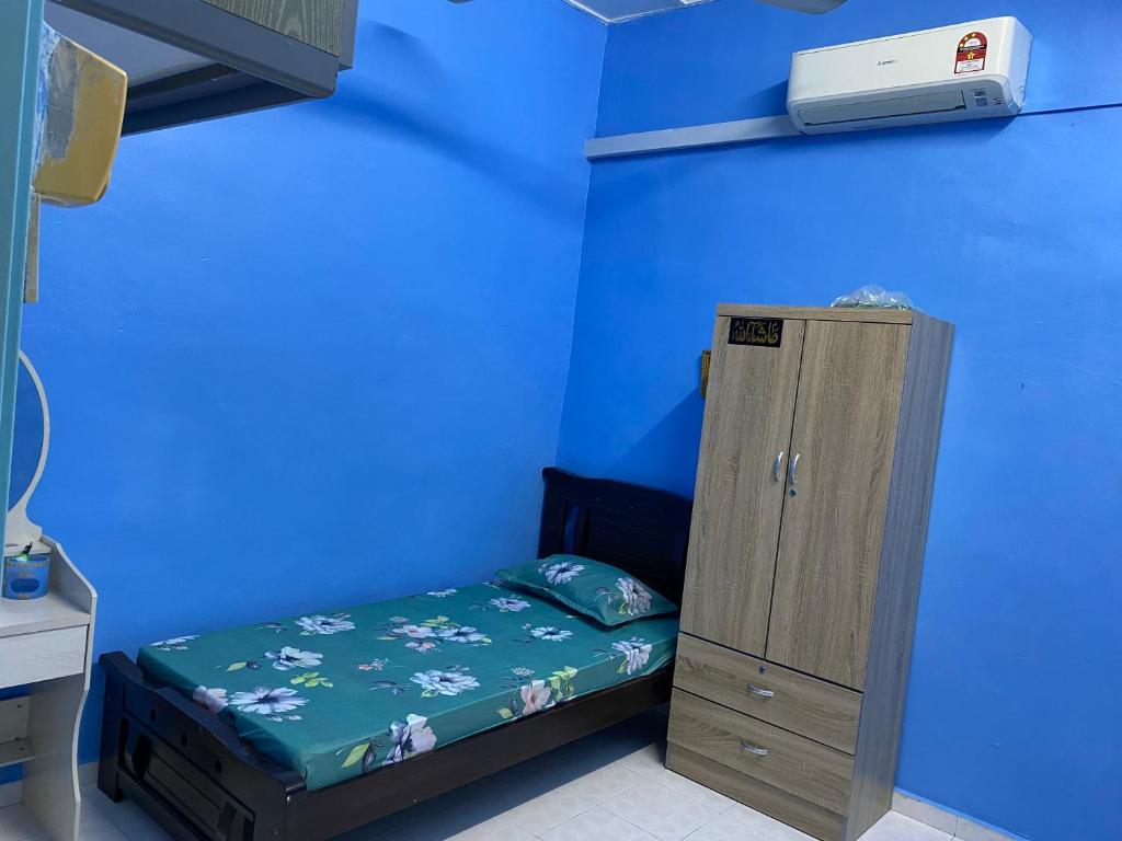 马六甲83 Homestay的一张小床,位于一个蓝色的墙壁内