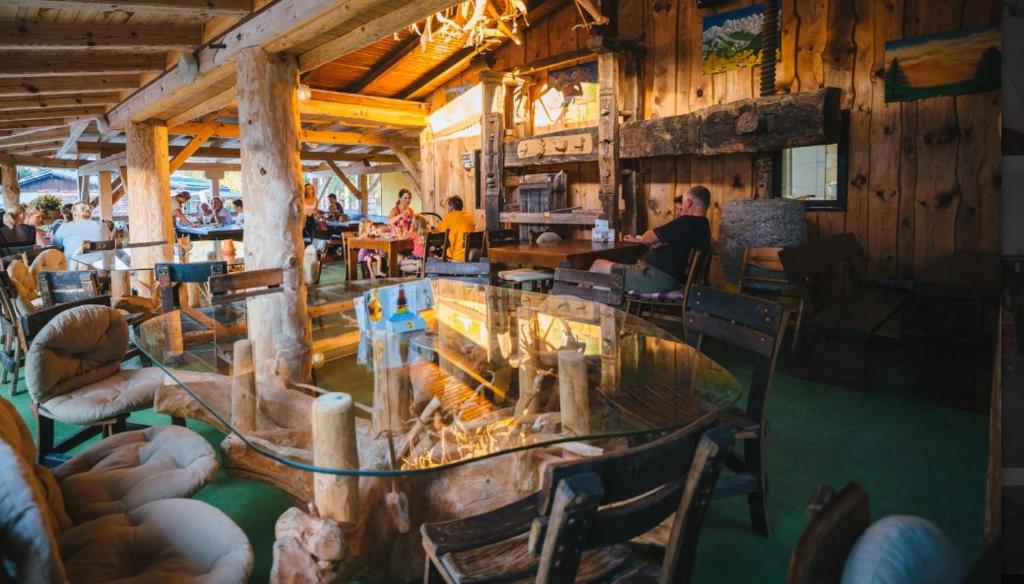 Rečica ob SavinjiForest Lodge Camping Menina的餐厅设有玻璃桌和椅子,可供住客用餐