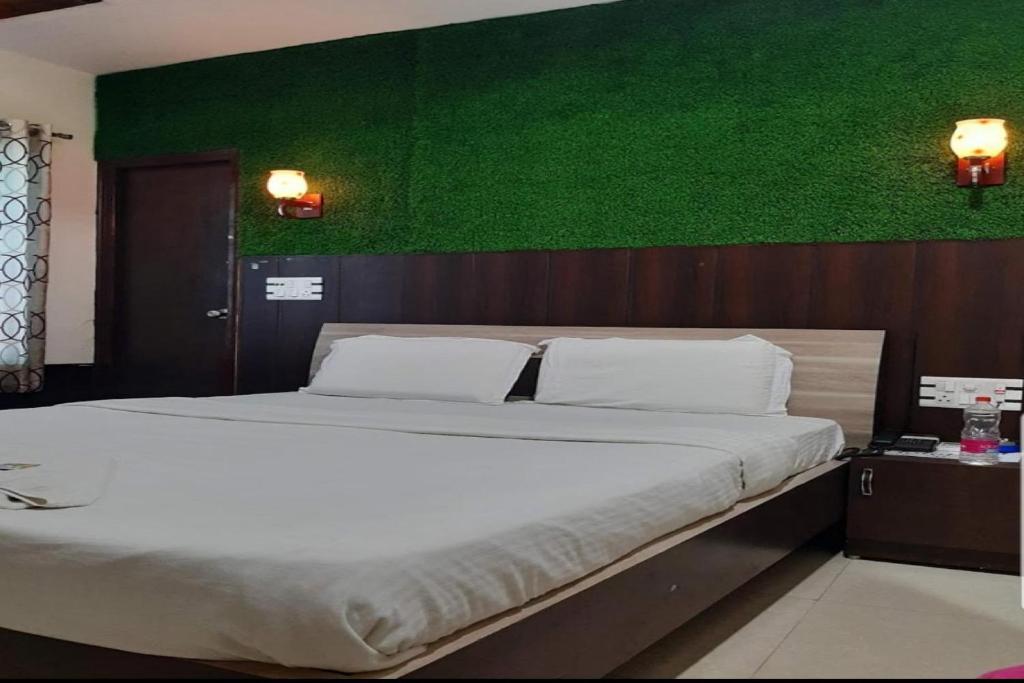 NārnaulOYO Spicy Town的一间卧室设有一张大床和绿色的墙壁