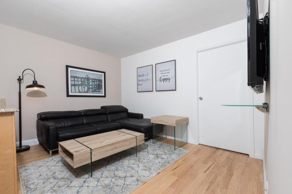 纽约Awesome 2 Bedroom Apartment in NYC的客厅配有黑色真皮沙发和桌子