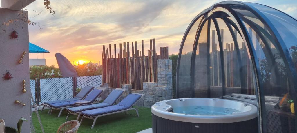 卡拉塔瑞达Sunset sea view & garden Spa Cala Tarida 6p max的享有热水浴池和庭院椅子的景色