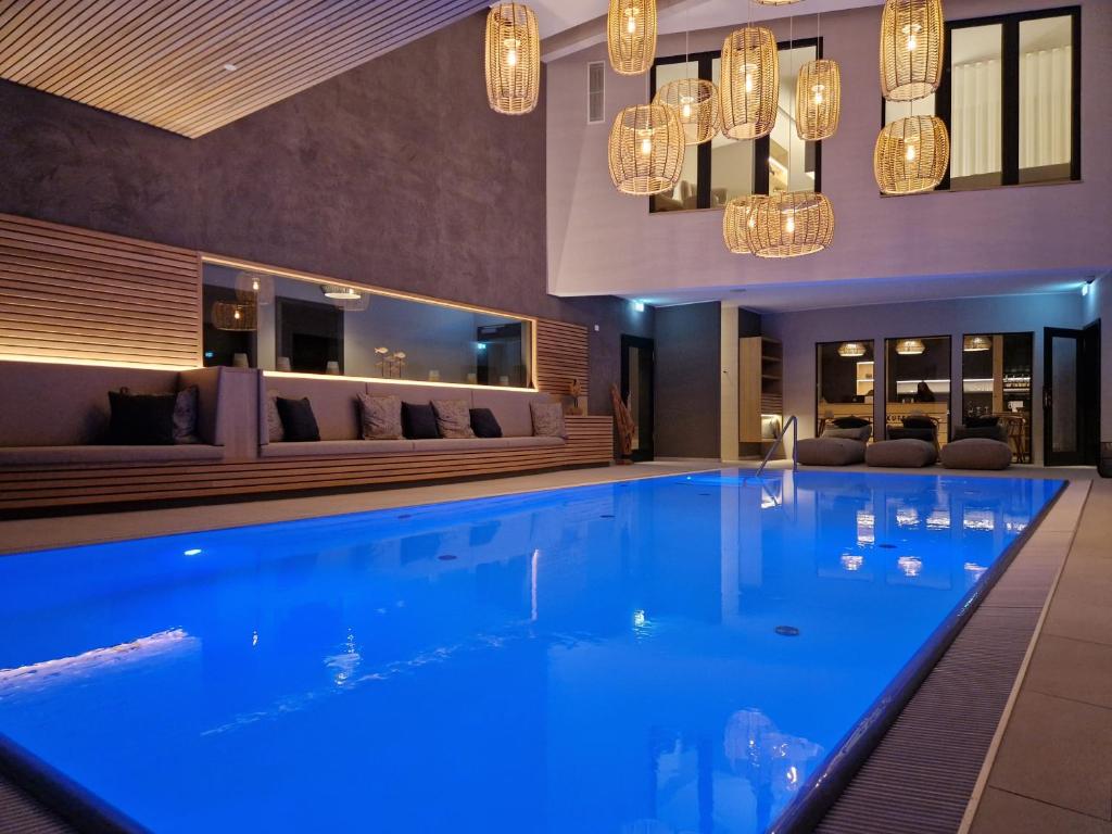 罗斯托克Landhotel Rittmeister & Kräuter-SPA Adults Only的一座带吊灯的酒店游泳池