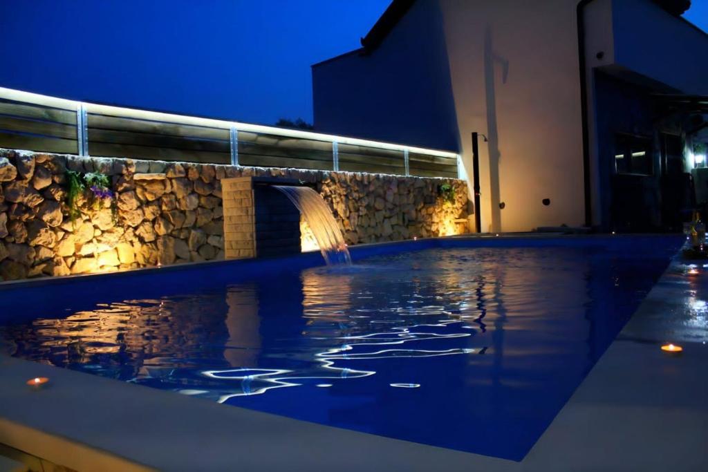 柳布什基Estate - Villa Discovery的游泳池,在晚上设有喷泉