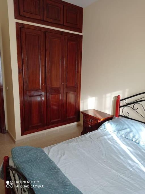 Souira GuedimaGrand appartement à deux pas de la plage的一间卧室配有一张床和一个木制橱柜
