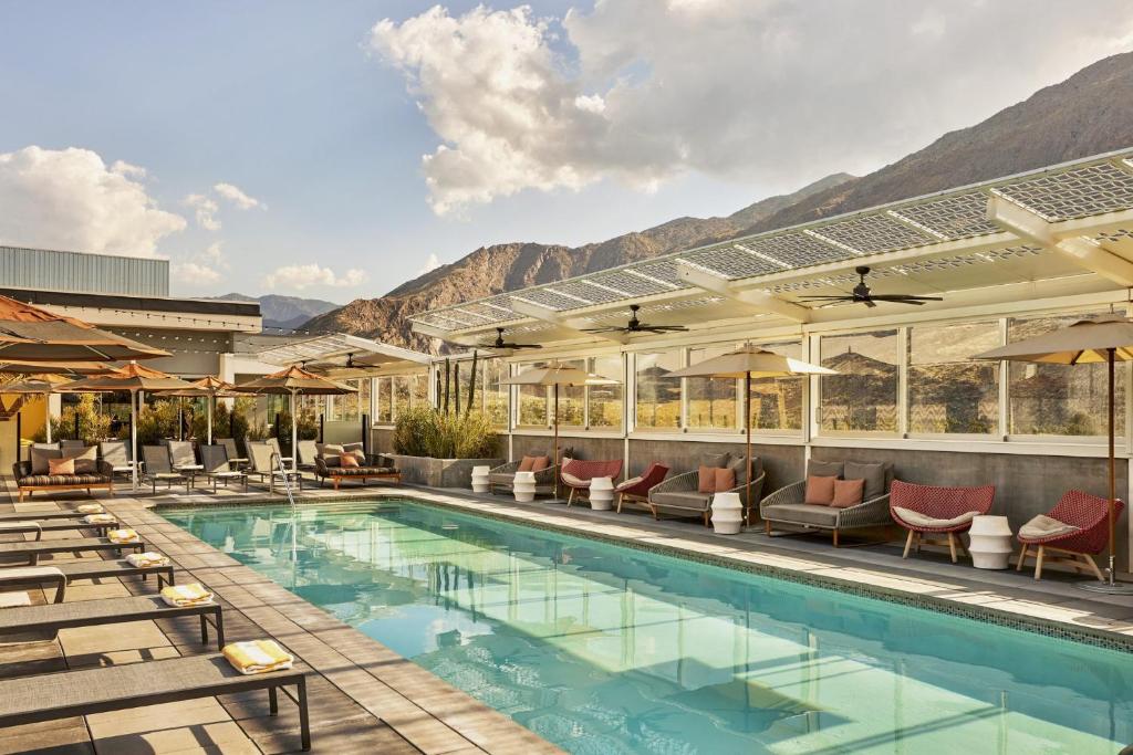 棕榈泉金普顿罗温棕榈泉酒店的一个带躺椅的游泳池,一个度假村