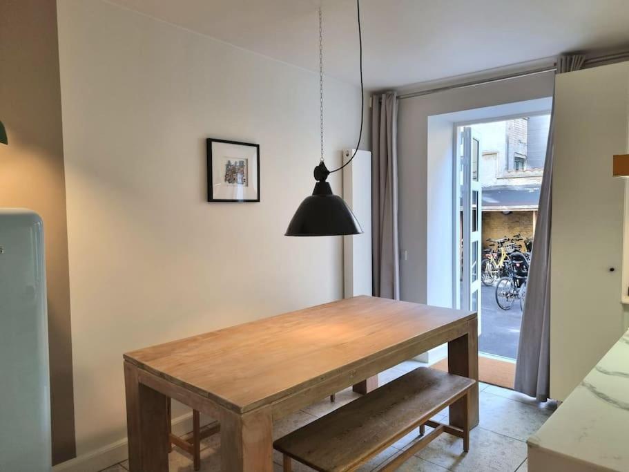 哥本哈根Hotellos的用餐室配有木桌和黑灯。