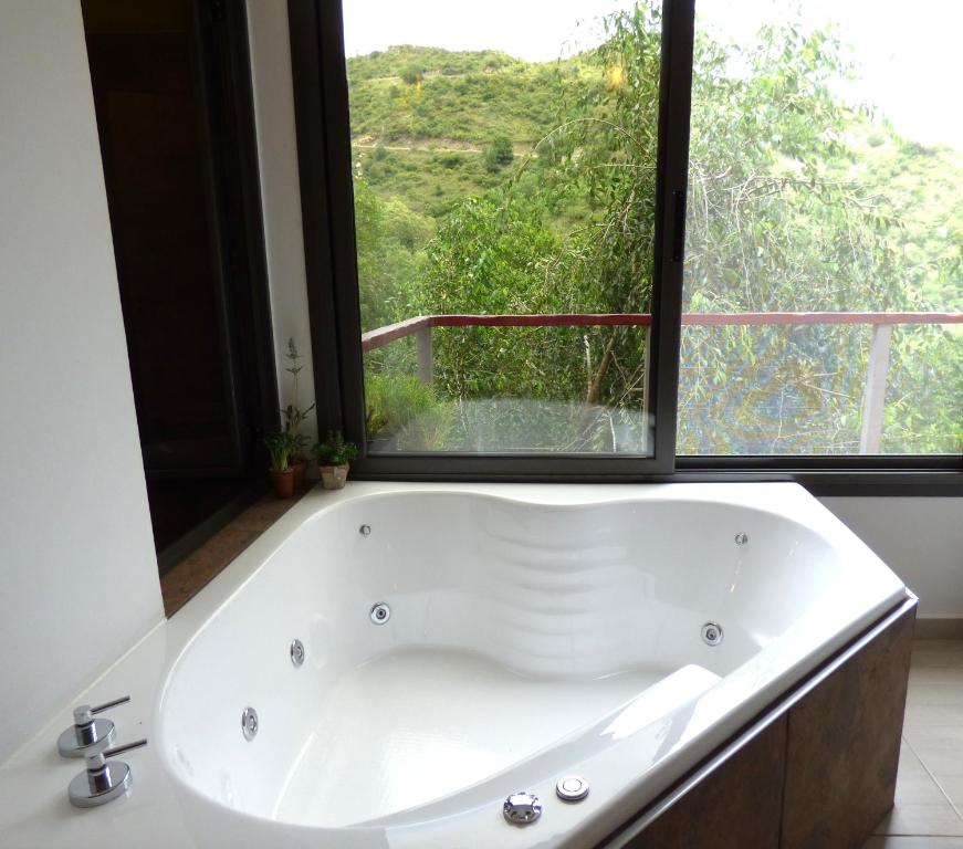 La CuestaMoradillo Apart的带窗户的浴室内的白色浴缸