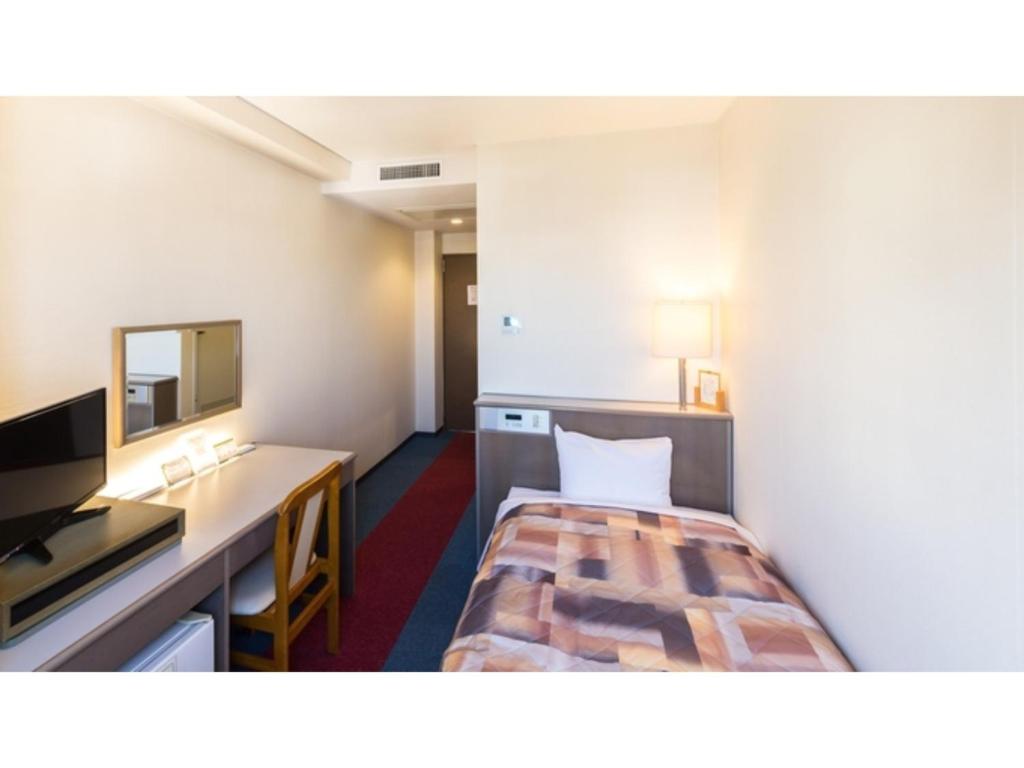 贝冢市Sunrise Inn - Vacation STAY 75396v的配有一张床和一张书桌的酒店客房