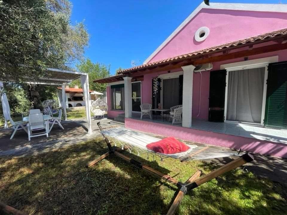 科孚镇Villa Penelope的粉红色的房子,在院子里有甲板