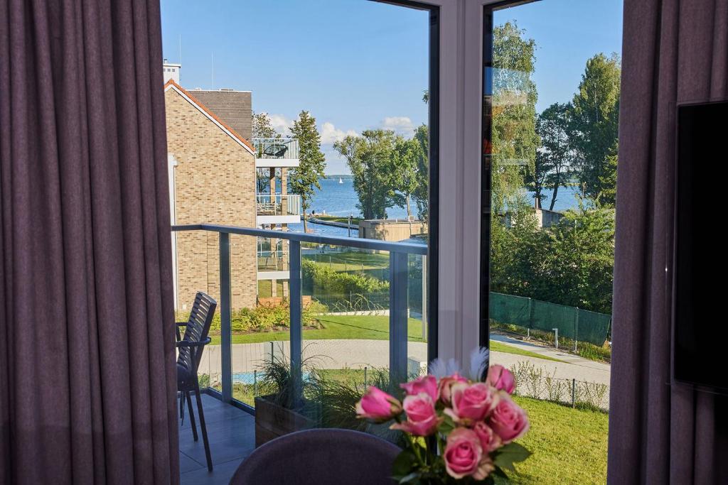 吉日茨科Apartament E10 w Nautica Resort nad jeziorem w Giżycku的窗前桌子上一束粉红色花