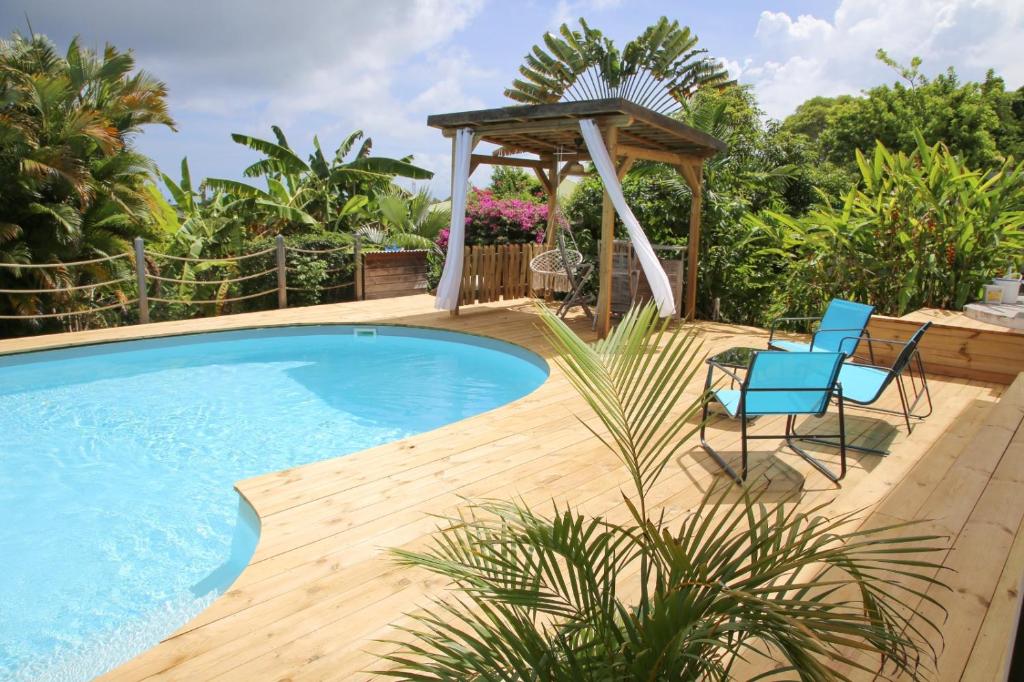 圣安尼L Orchidée Bleue, bas de villa, vue mer, piscine privée的一个带两把椅子的游泳池和一个凉亭